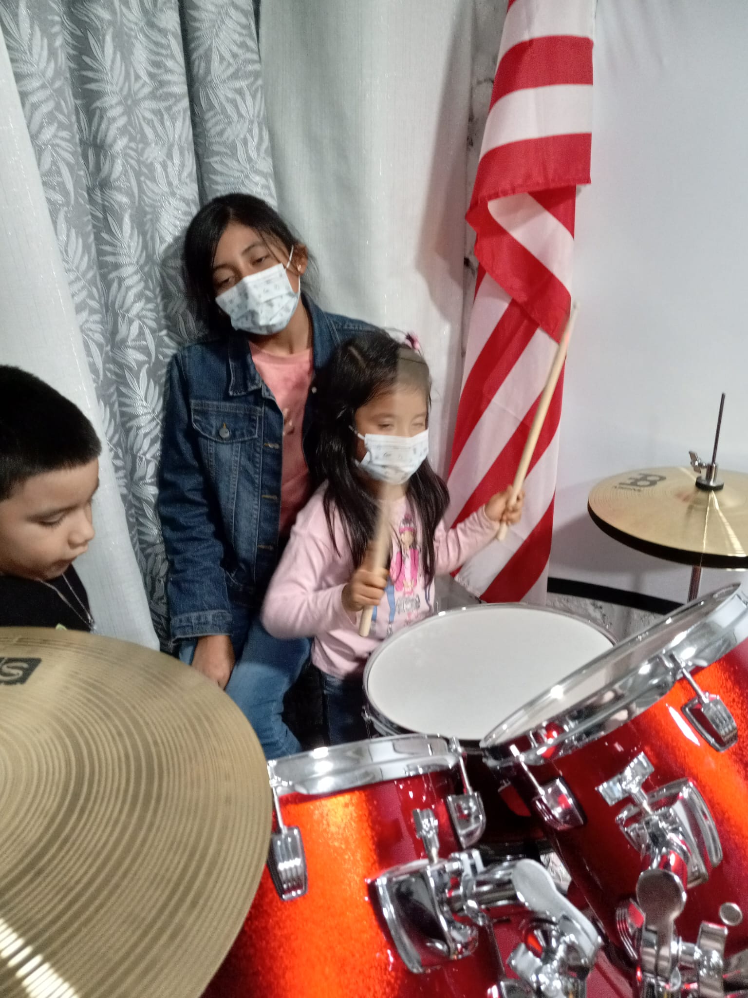 Niños de la iglesia aprendiendo a tocar la batería en el ministerio de alabanza